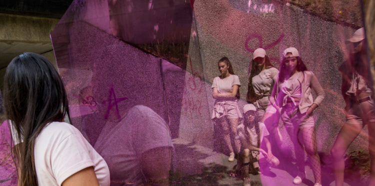 Girls standing against a concrete wall